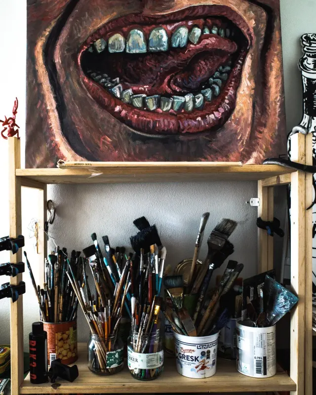 Pensler og et maleri i et atelier